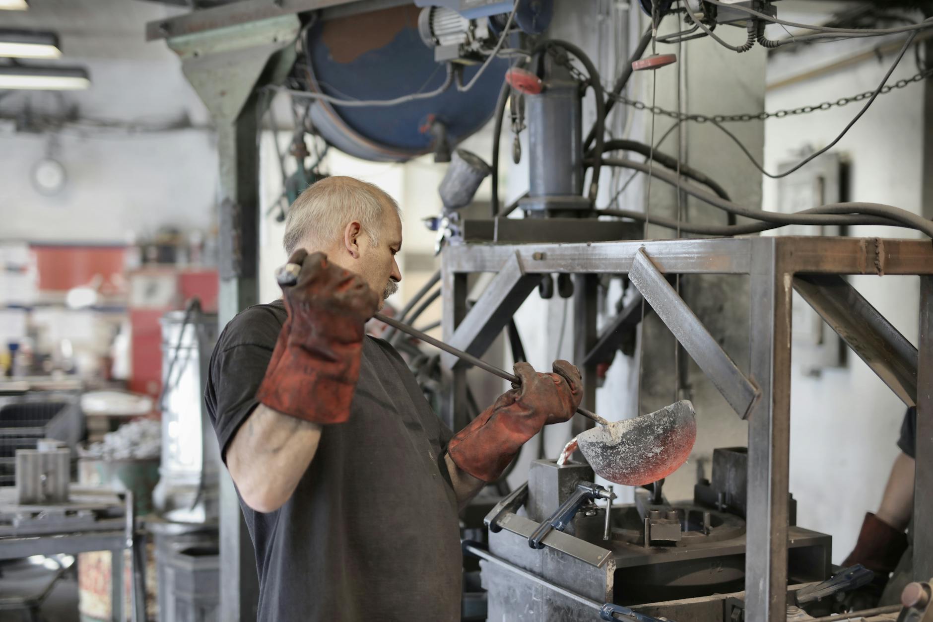 aged white hair metallurgist working in workshop