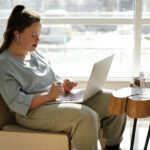 girl sitting on a couch using a laptop