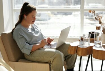 girl sitting on a couch using a laptop