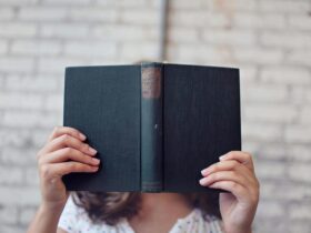 selective focus photography of woman holding book