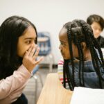 two girls gossiping with one another