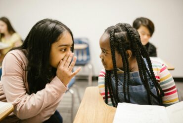 two girls gossiping with one another