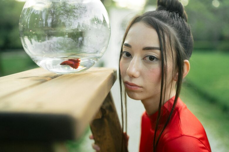 woman in red shirt looking at a fish bowl