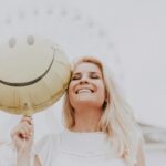 woman holding a smiley balloon