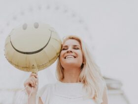 woman holding a smiley balloon